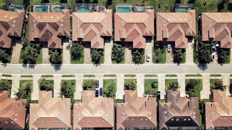 "Arial view of Florida rooftops, showcasing a variety of roof styles and colors under the clear blue sky."